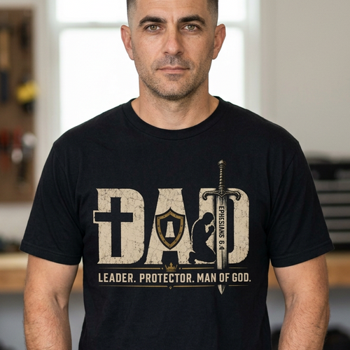 Christian graphic t-shirt featuring the word “Dad” with faith-inspired symbols including a cross, shield, sword, praying figure, and the phrase “Leader. Protector. Man of God.” with Ephesians 6:4.