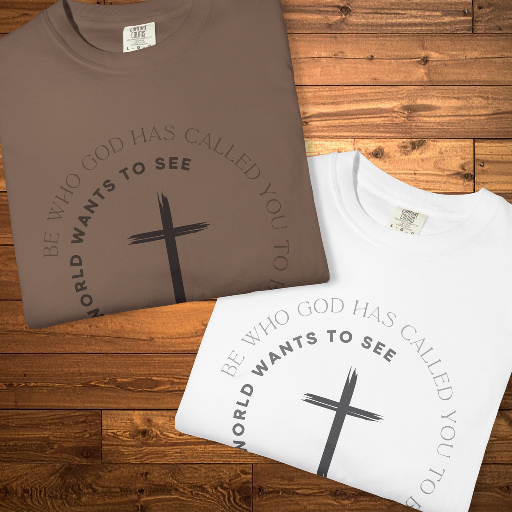 Folded espresso brown and white colorways Christian graphic t-shirt featuring a black cross and the message “Be who God has called you to be, not what the world wants to see” in a circular design.