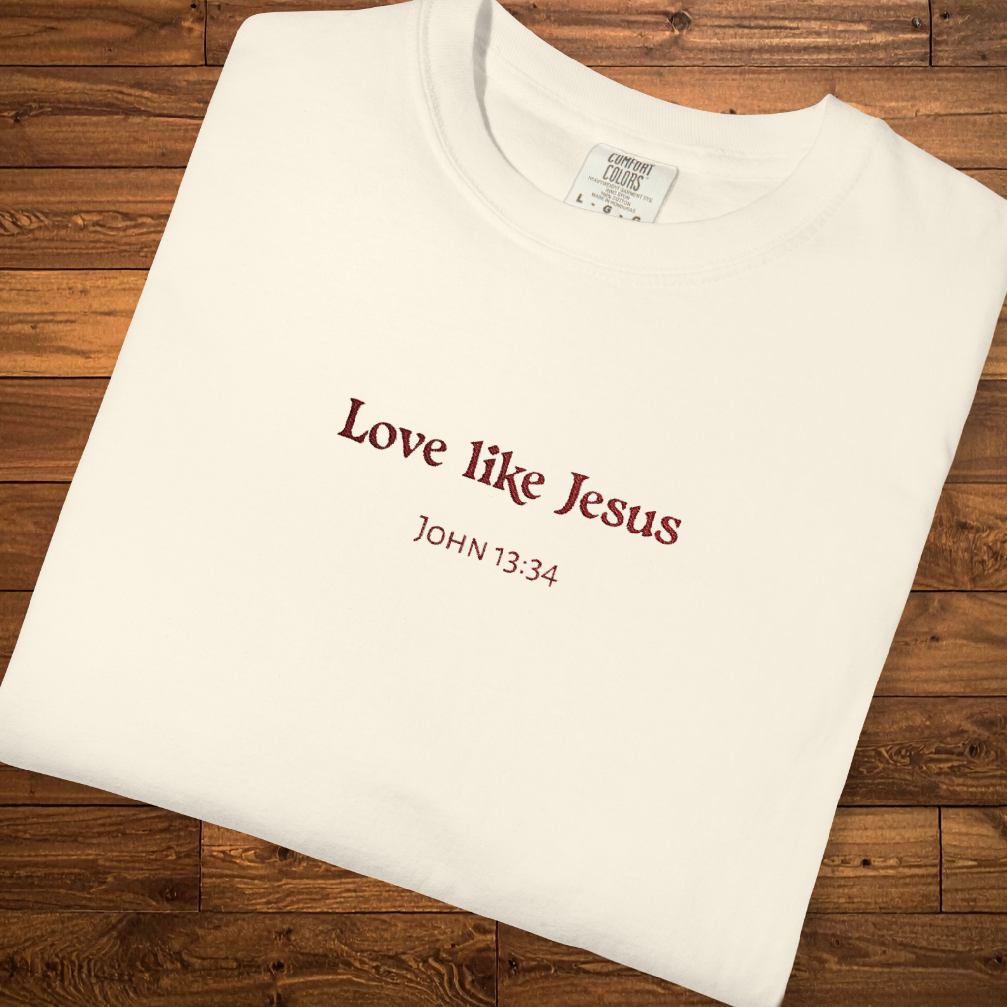 Faith-based garment-dyed t-shirt in ivory featuring the embroidered-style message “Love Like Jesus” with John 13:34 centered on the chest.