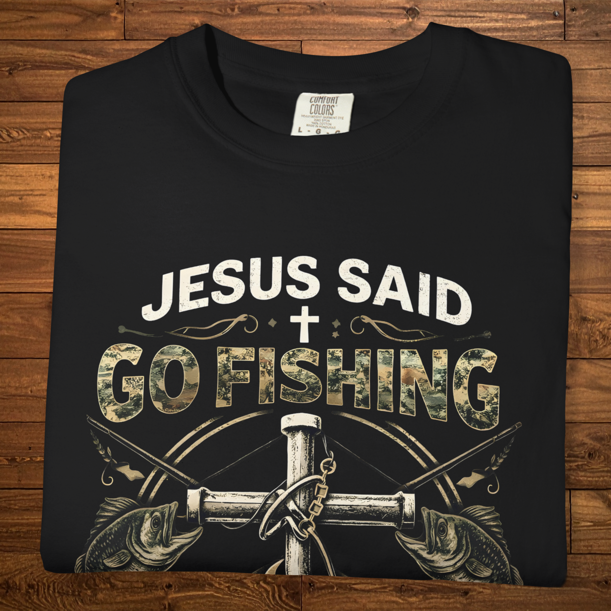 Black Christian fishing t-shirt featuring the phrase “Jesus Said Go Fishing” with bass fish artwork, a cross, fishing tackle, and Luke 5:4.